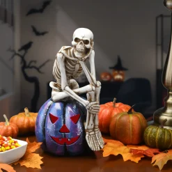 New National Tree Company 11 in. Halloween Skeleton Resting on a Purple Galaxy Jack O Lantern